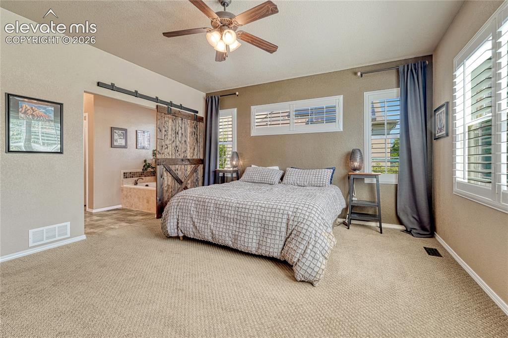 Image 5 of 50: Private master bedroom suite with a fantastic barn door to the bathroom 