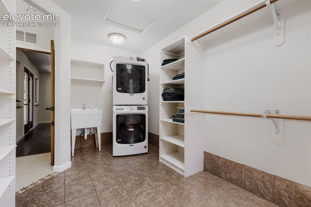 Image 36 of 50: Primary closet with own laundry and sink