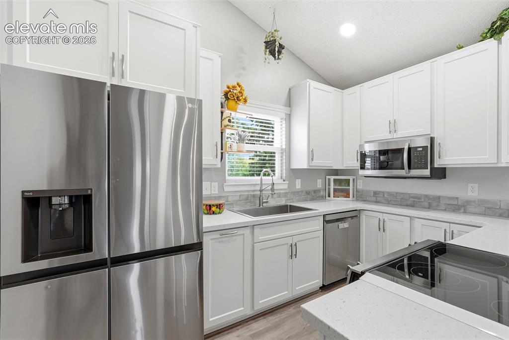 Image 10 of 45: Modern kitchen featuring stainless steel appliances, white shaker cabinetry