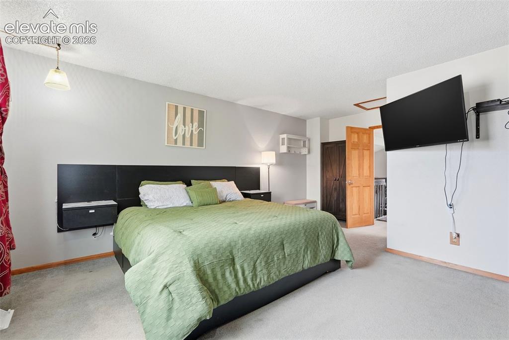 Image 18 of 45: Carpeted room featuring light gray walls, white trim, and a warm wood-panel