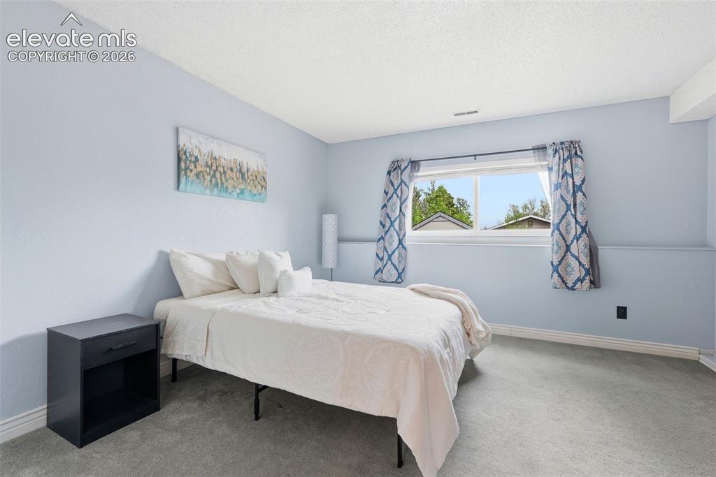 Image 22 of 45: Spacious room with light blue walls, white trim, and light gray carpeting