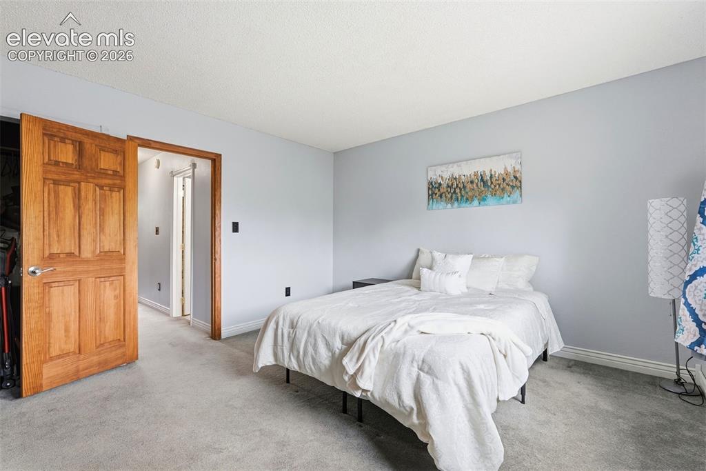 Image 23 of 45: Spacious room featuring light gray carpeting, neutral wall color, and white