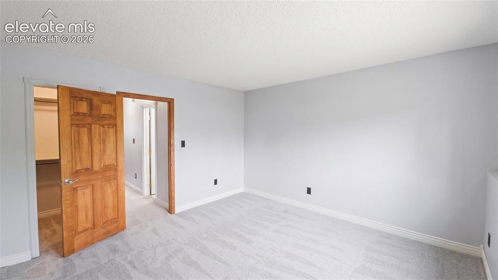 Image 23 of 45: Spacious room featuring light gray carpeting, neutral wall color, and white