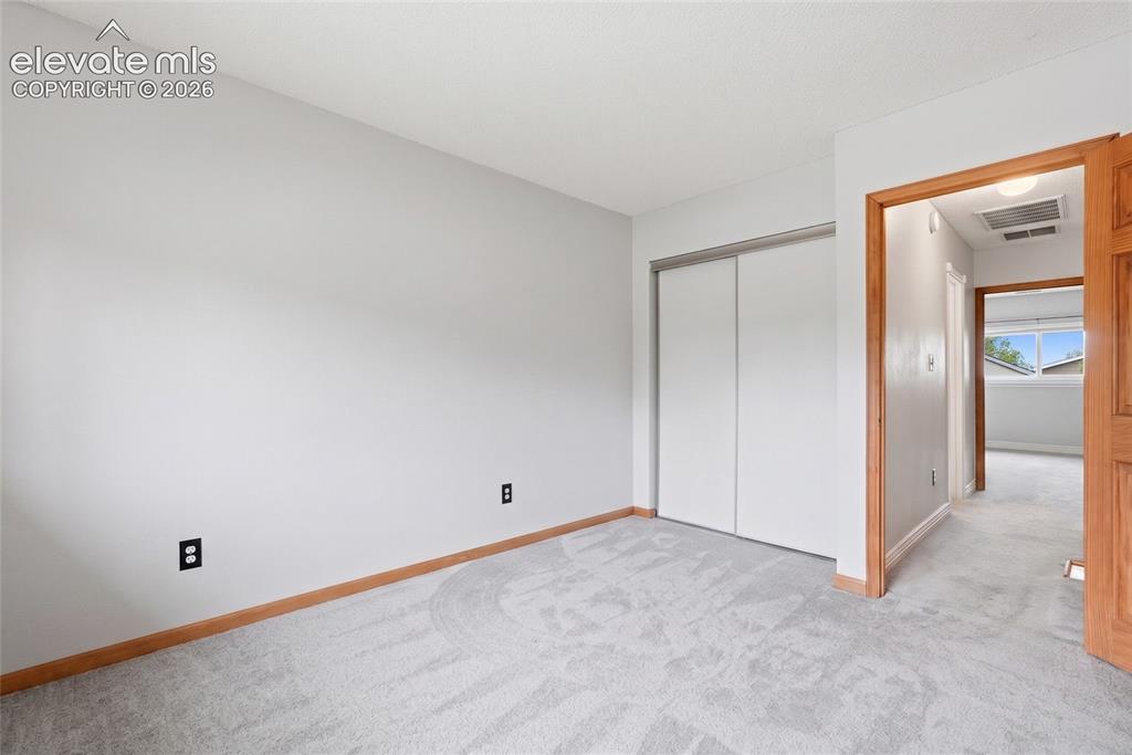Image 25 of 45: Bedroom featuring light gray wall paint, light gray carpeting, wood baseboa