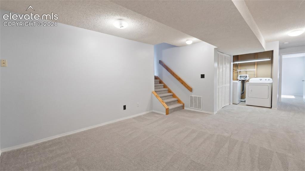 Image 28 of 45: Carpeted lower level with light gray walls