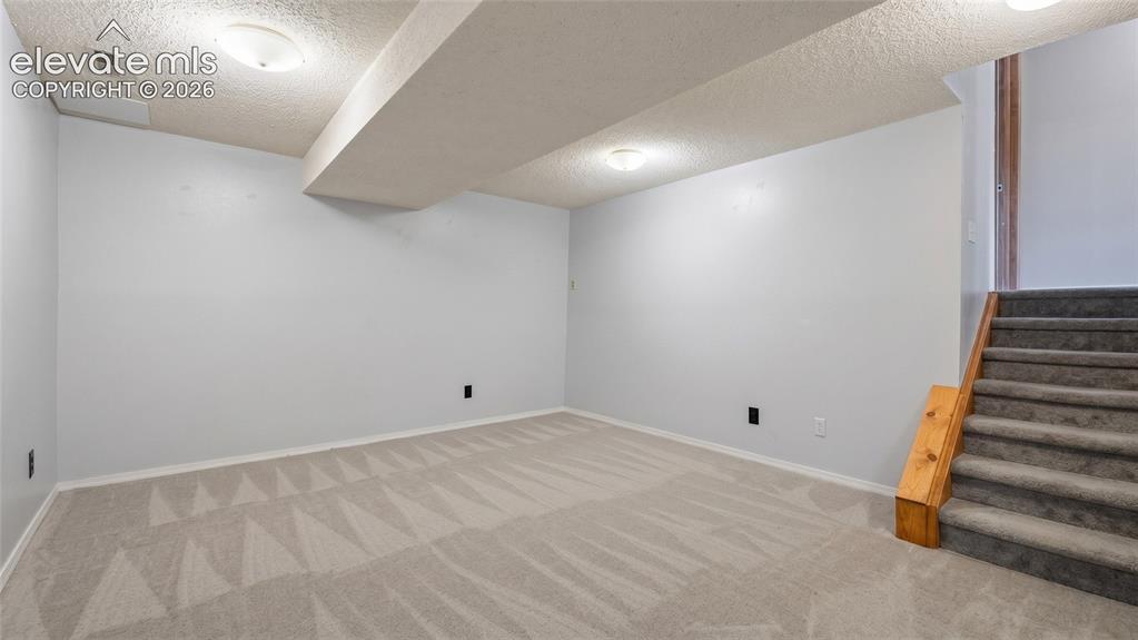 Image 29 of 45: Spacious room featuring light gray walls, patterned carpet flooring, ceilin