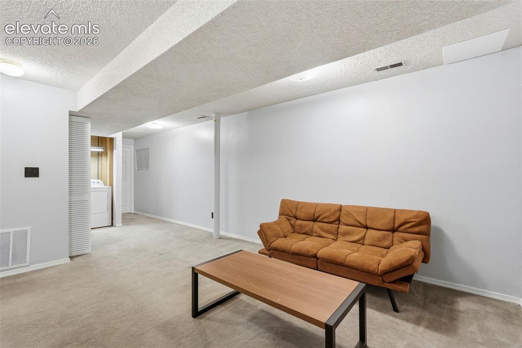 Image 30 of 45: Spacious lower-level area featuring light gray carpeting and freshly painte