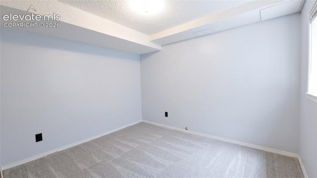 Image 31 of 45: Carpeted room featuring light blue walls, white trim, a textured white ceil