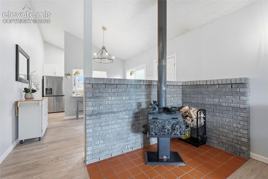 Image 7 of 45: Cast iron wood-burning stove with ornate detailing, set on terracotta tile
