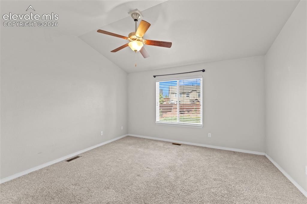 Image 12 of 40: Bright bedroom featuring neutral carpeting, a ceiling fan with integrated l