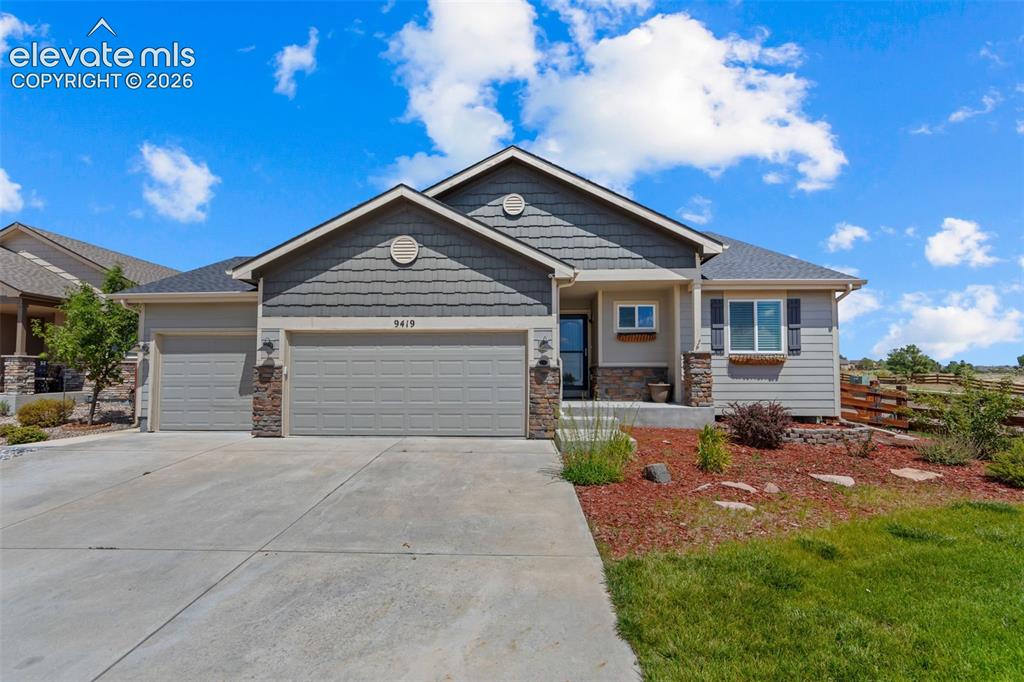 Image 2 of 40: Welcoming front elevation featuring a two-car garage with paneled doors, st