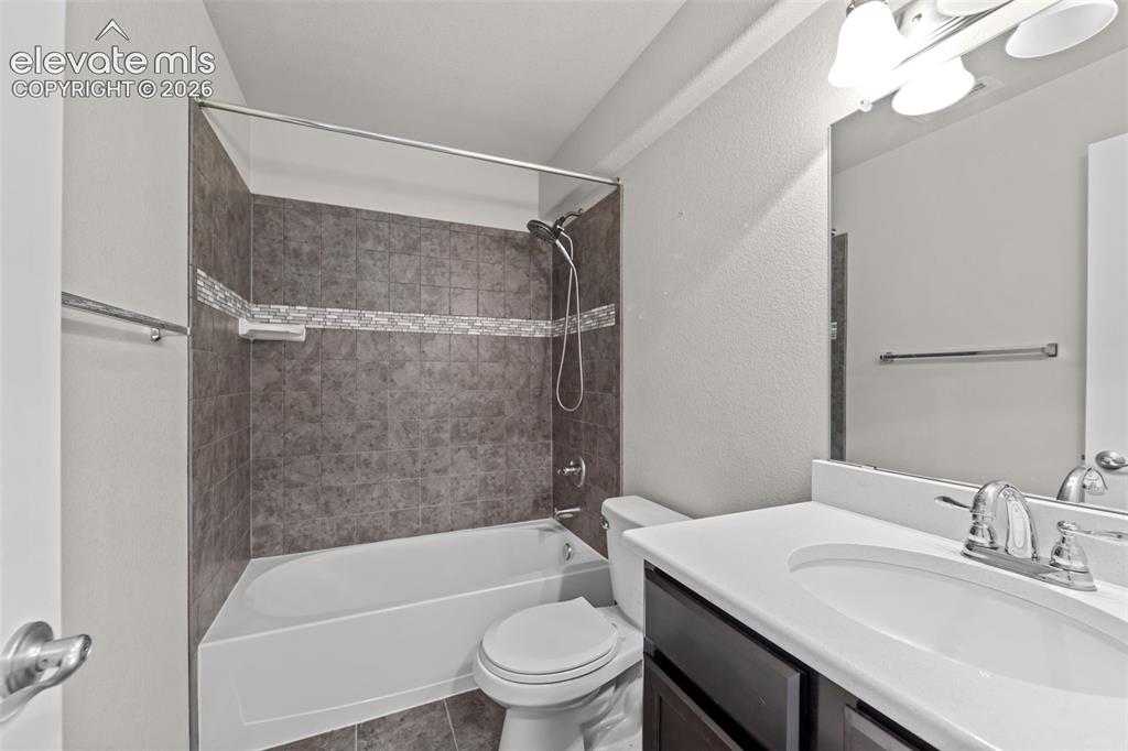 Image 23 of 40: Bathroom featuring a white vanity with integrated sink, dark wood-finish ca