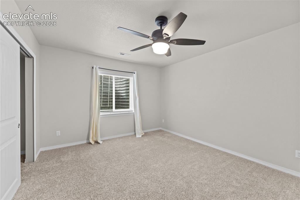Image 24 of 40: Wall-to-wall carpeting with light-toned walls, featuring a window and a cei