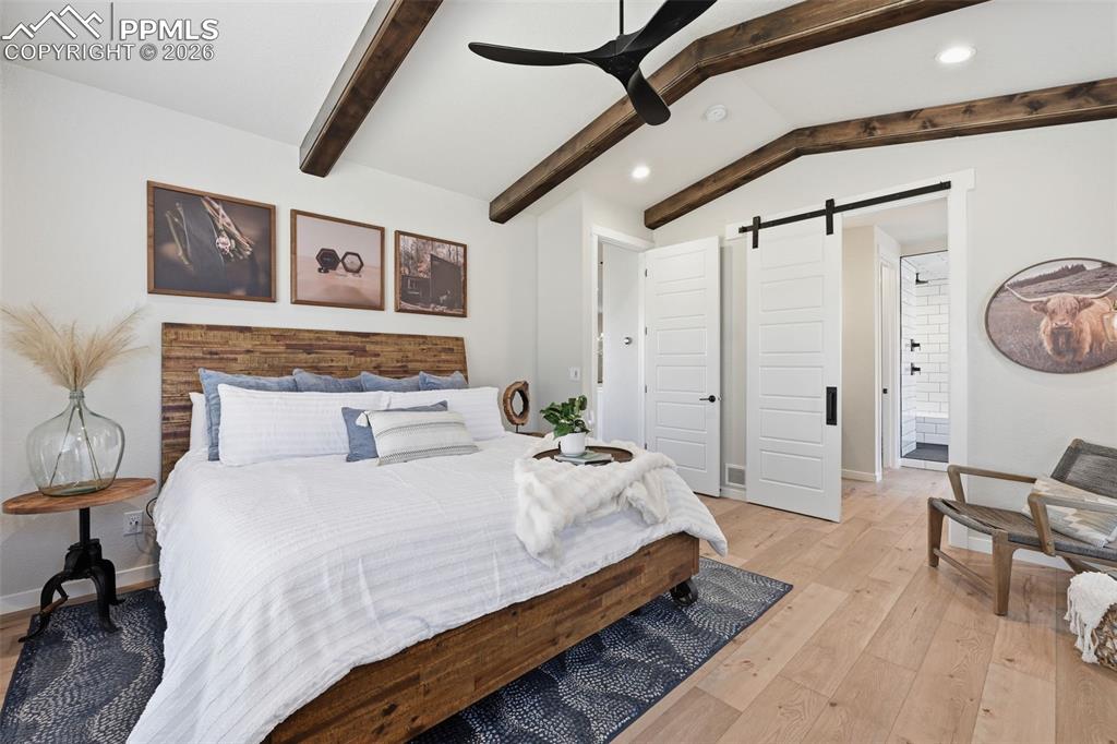 Image 22 of 46: Vaulted ceiling with beams and barn door to Master Bth