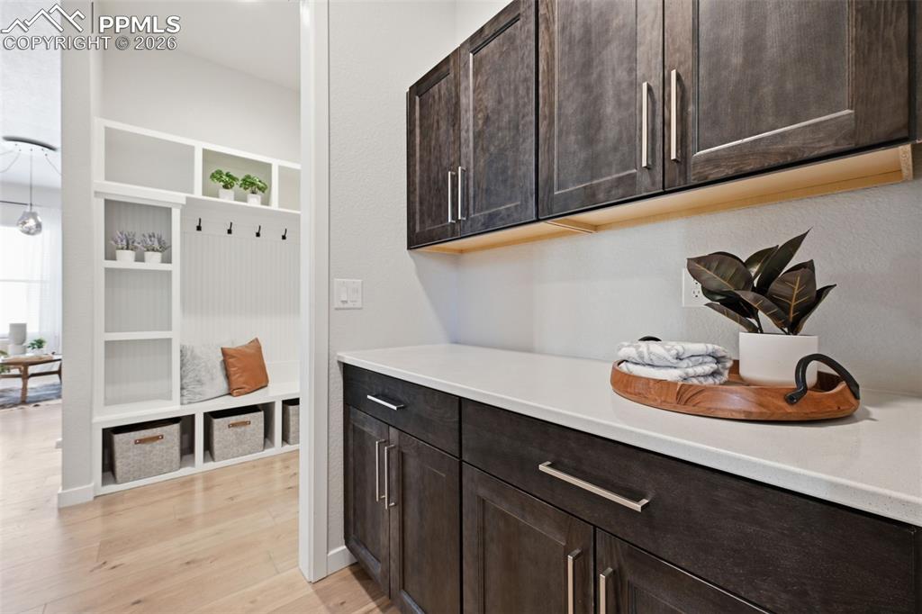 Image 27 of 46: Cabinet storage in the laundry with quartz countertops