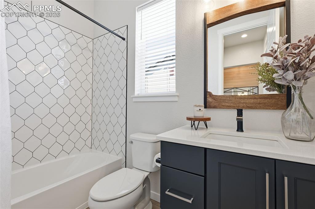 Image 31 of 46: Full bathroom with upgraded tile and quartz countertops