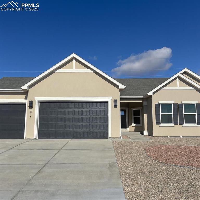 Caption: Single story home with stucco siding, driveway, an attached garage, and roof with shingles