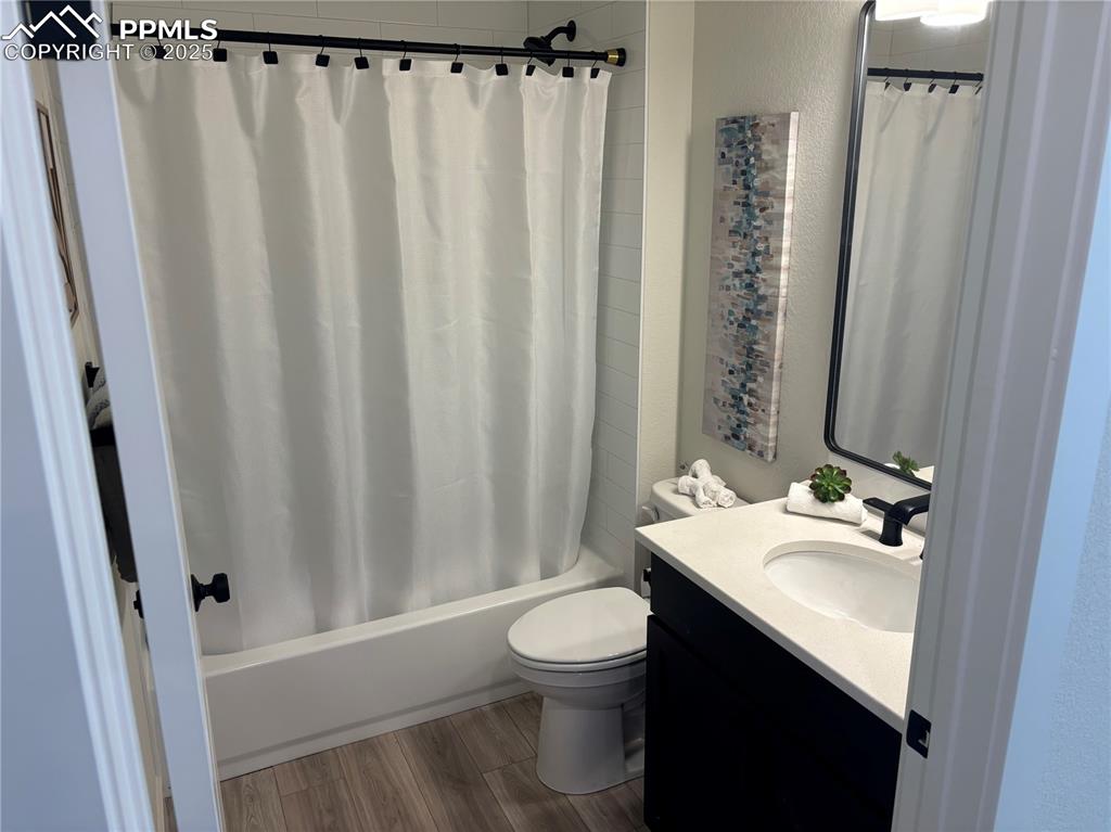 Image 12 of 19: Full bathroom with vanity, shower / tub combo with curtain, dark wood finis