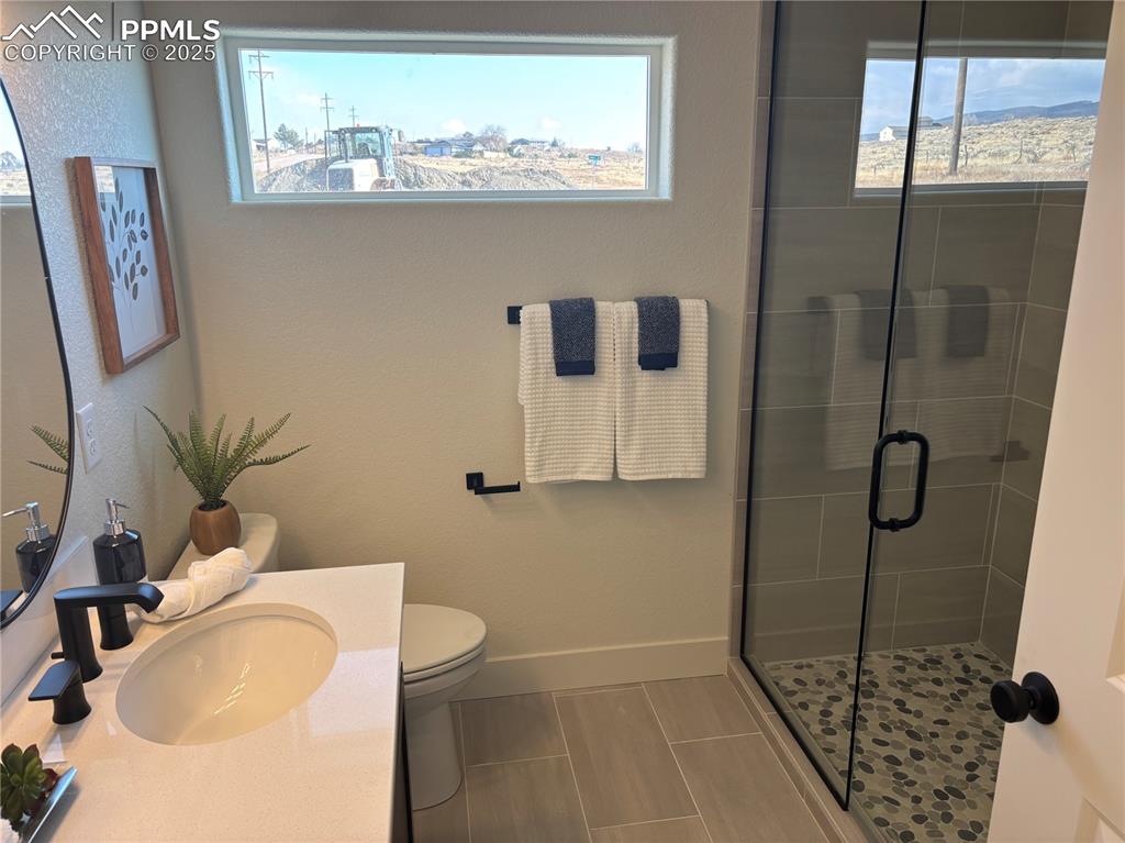 Image 16 of 19: Full bathroom with a stall shower, vanity, tile patterned flooring, and a t