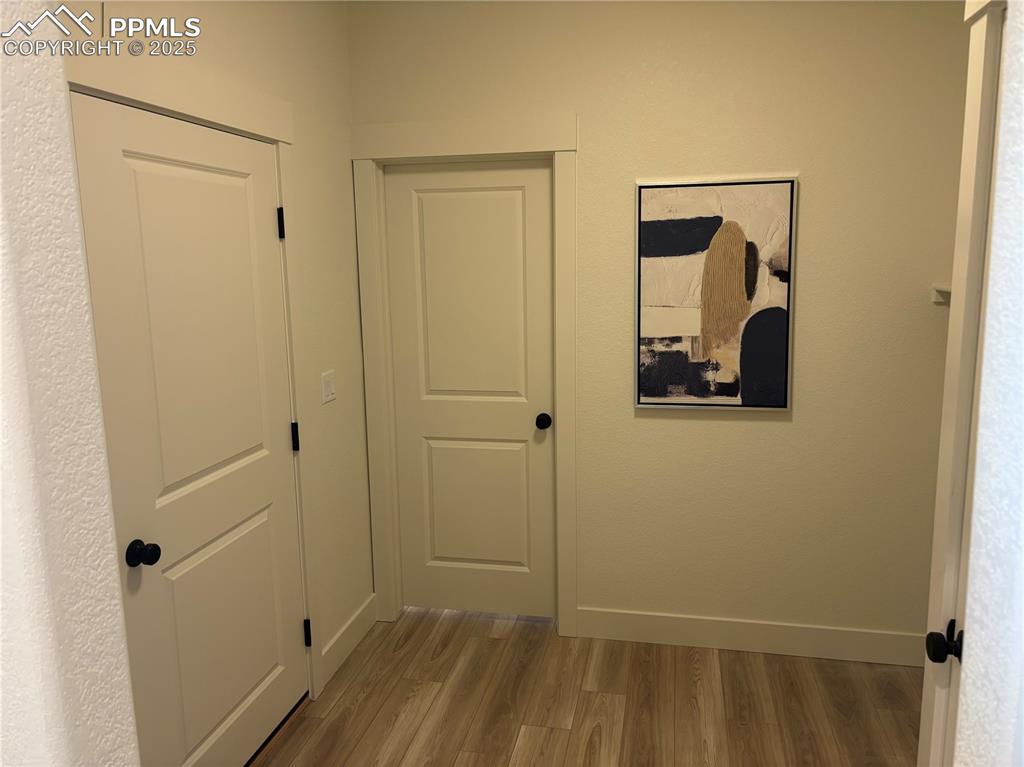 Image 4 of 19: Corridor featuring wood finished floors and baseboards