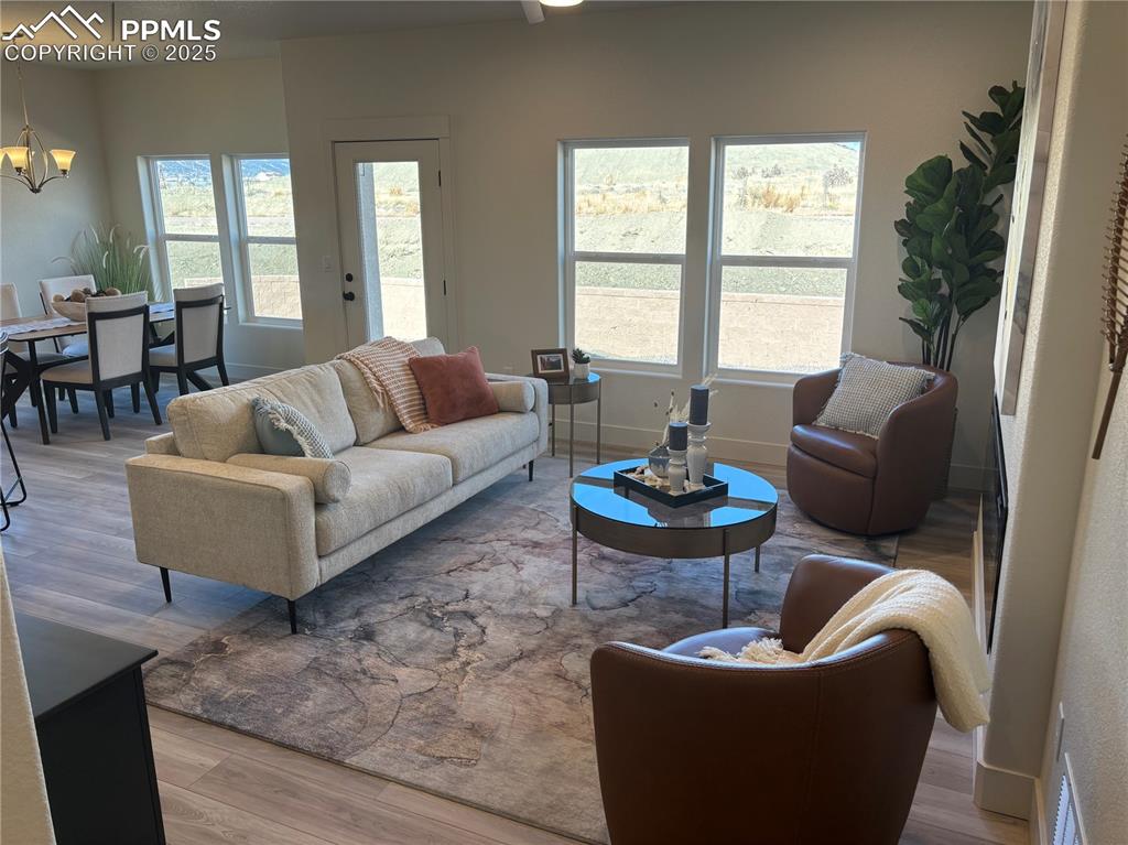 Image 5 of 19: Living room with light wood-style flooring and a chandelier