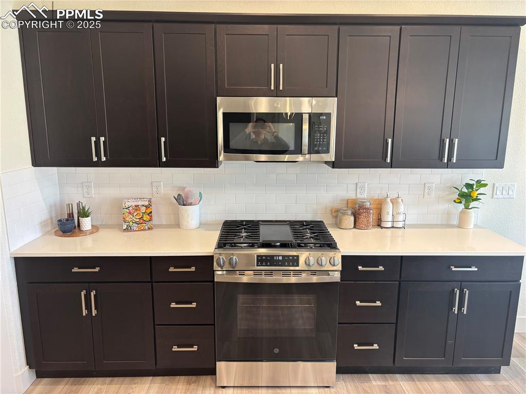 Image 9 of 19: Kitchen featuring stainless steel appliances, light wood-style floors, ligh
