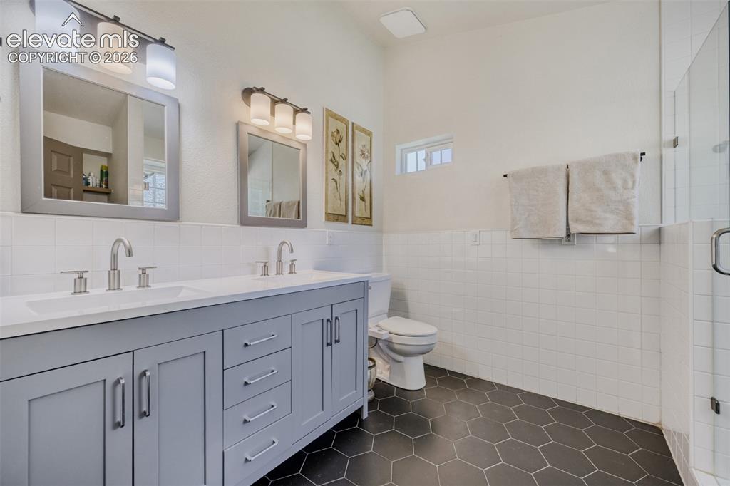 Image 18 of 29: Dual vanity with light gray cabinetry, brushed 
nickel hardware, and 
whi