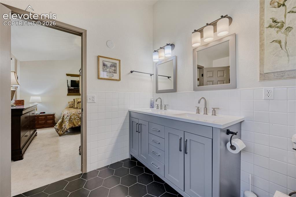 Image 19 of 29: Double vanity with gray cabinetry and white countertop, featuring dual mirr