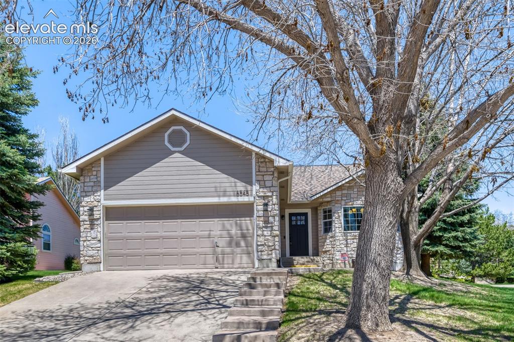 Image 2 of 29: Stone and siding exterior with an attached garage
