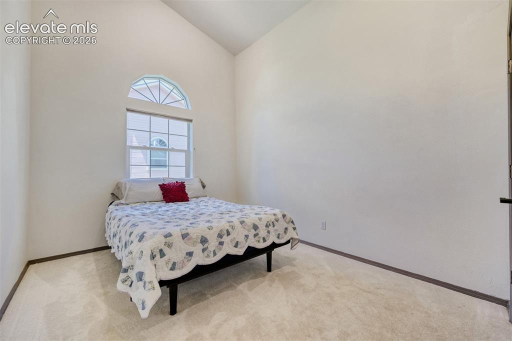 Image 22 of 29: Vaulted ceiling room featuring a large arched
 window, light neutral 
car