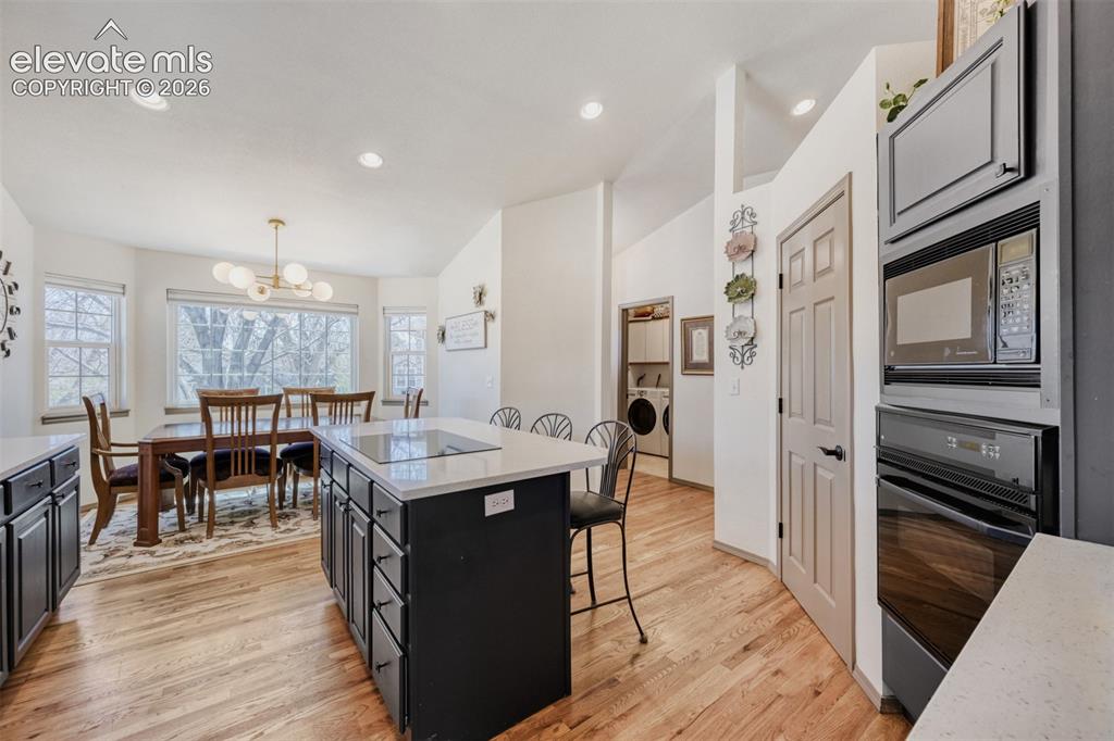 Image 8 of 29: Kitchen featuring a central island with an 
integrated cooktop, light-tone