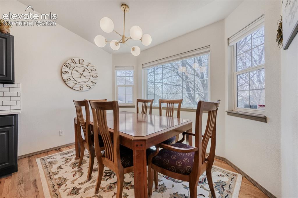 Image 9 of 29: Dining area featuring wood-finish flooring, a 
contemporary brass chandeli