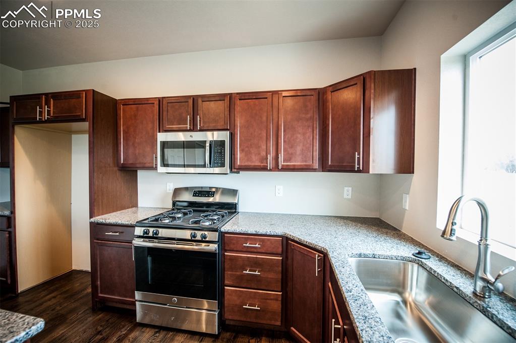Image 8 of 29: Kitchen featuring island, granite counters, and stainless appliances
