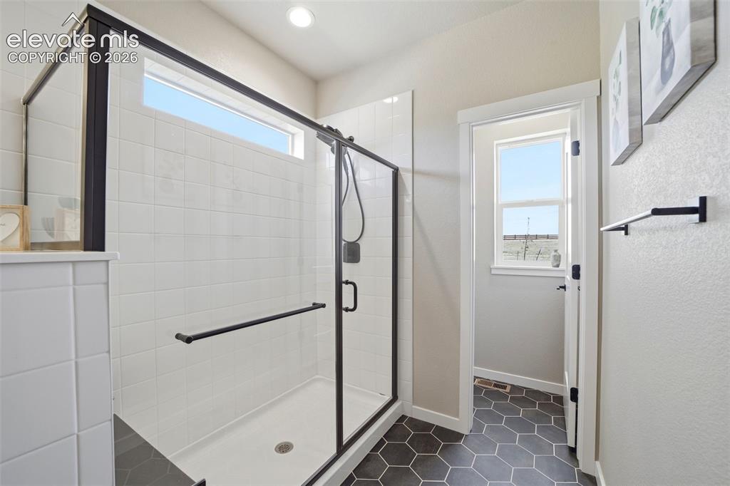 Image 20 of 49: Extended shower with a bench, and a private water closet (with a window). 