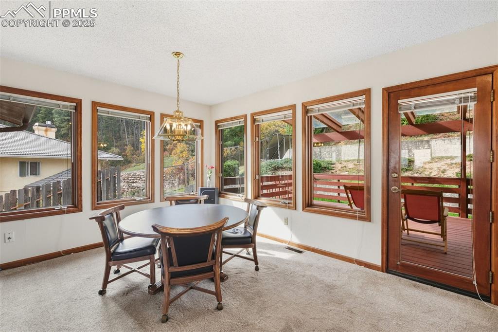 Image 43 of 48: Casual dining area off kitchen in family room with walkout to large deck
