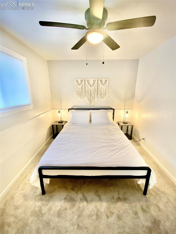Image 12 of 28: 211-Unit B Bedroom 2  with light colored carpet and a ceiling fan