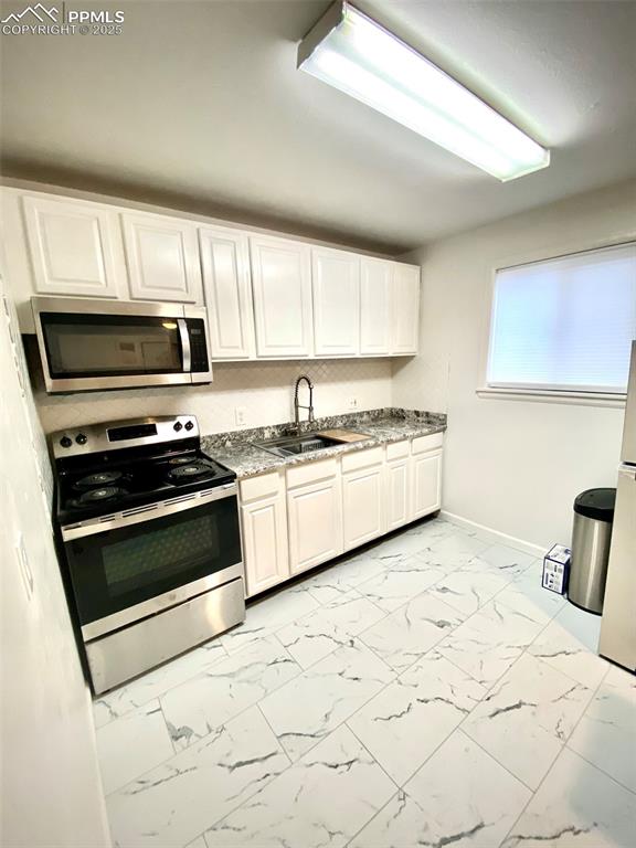 Image 15 of 28: 211-B  Kitchen with appliances with stainless steel finishes, white cabinet