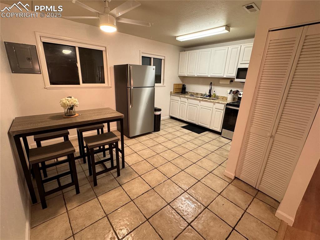 Image 21 of 28: 211-Unic C Kitchen with stainless steel appliances, white cabinetry, and a 