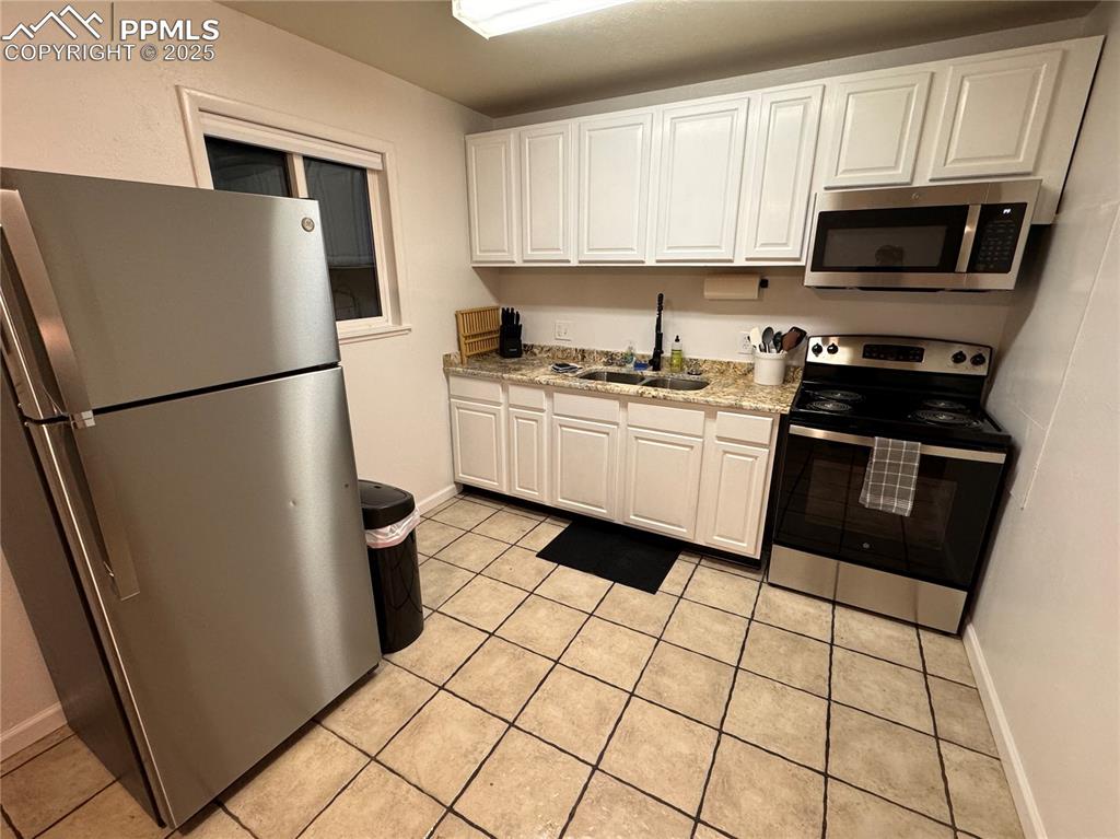 Image 22 of 28: 211-Unit C Kitchen featuring stainless steel appliances, white cabinetry, l