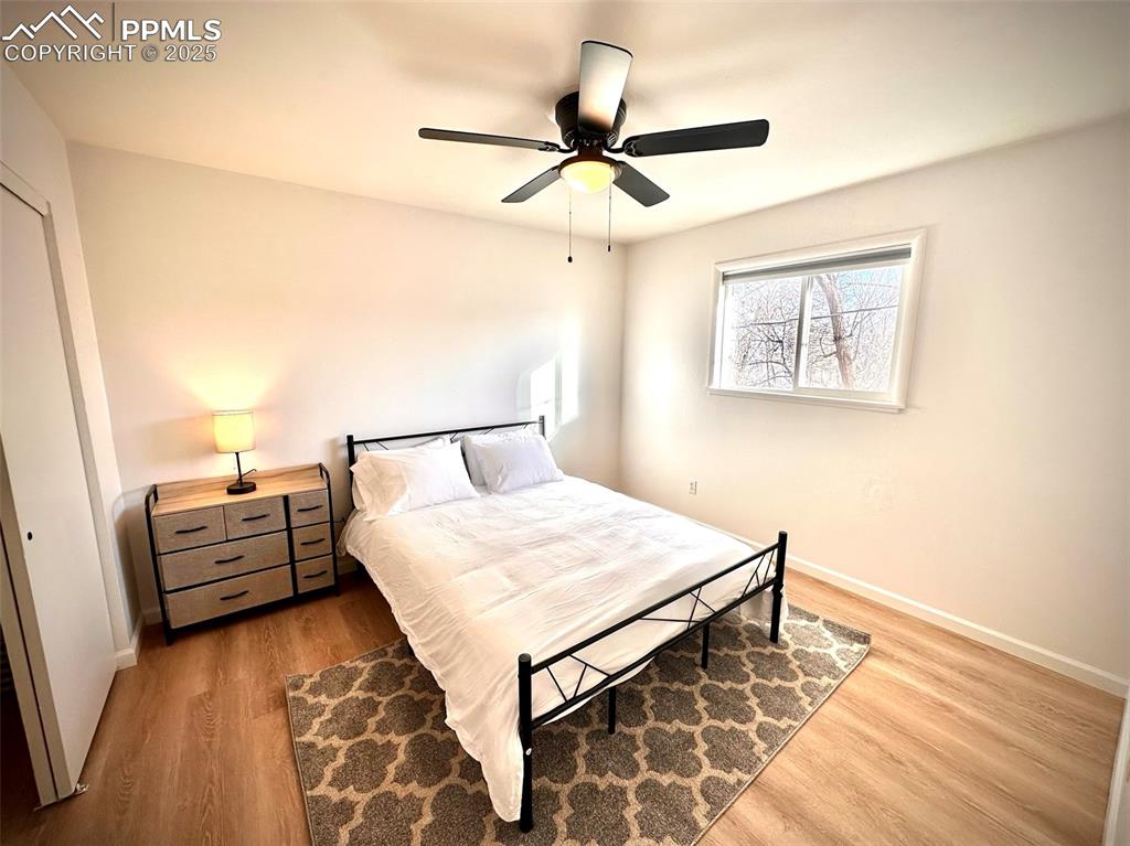 Image 25 of 28: 211-Unit D Bedroom 2 with light wood-type floor and a ceiling fan