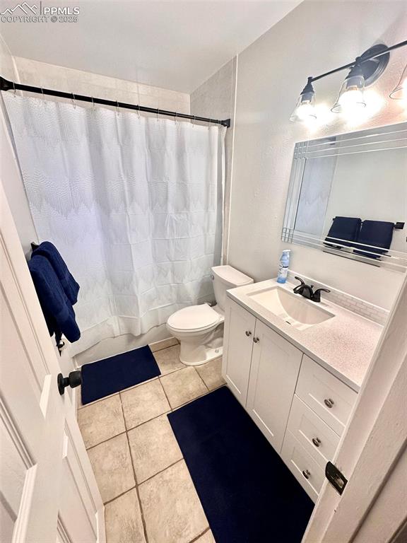 Image 26 of 28: 211-Unit D  Full bath featuring vanity, light tile patterned floors, and tu