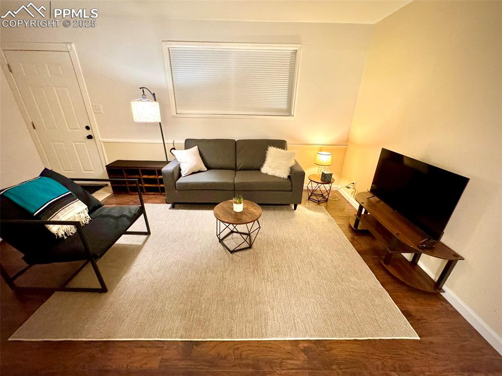 Image 5 of 28: 211-Unit A  Living area featuring dark wood-like floors