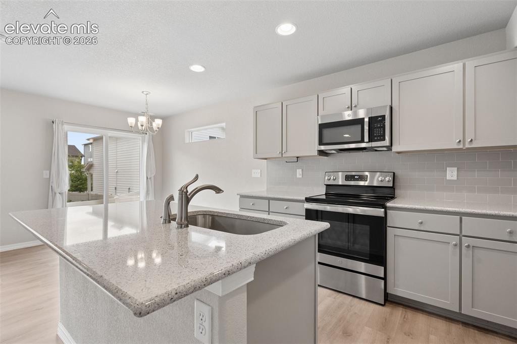 Image 14 of 36: The Kitchen showcases gorgeous granite countertops, an island countertop, a