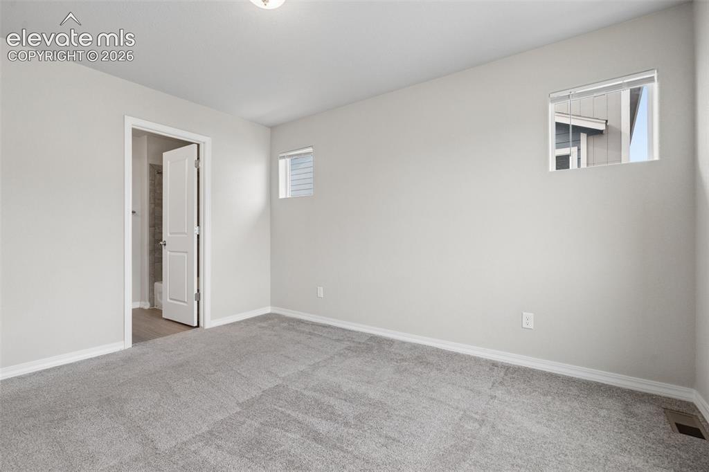 Image 26 of 36: Two additional bedrooms are found on the upper level and can be utilized as