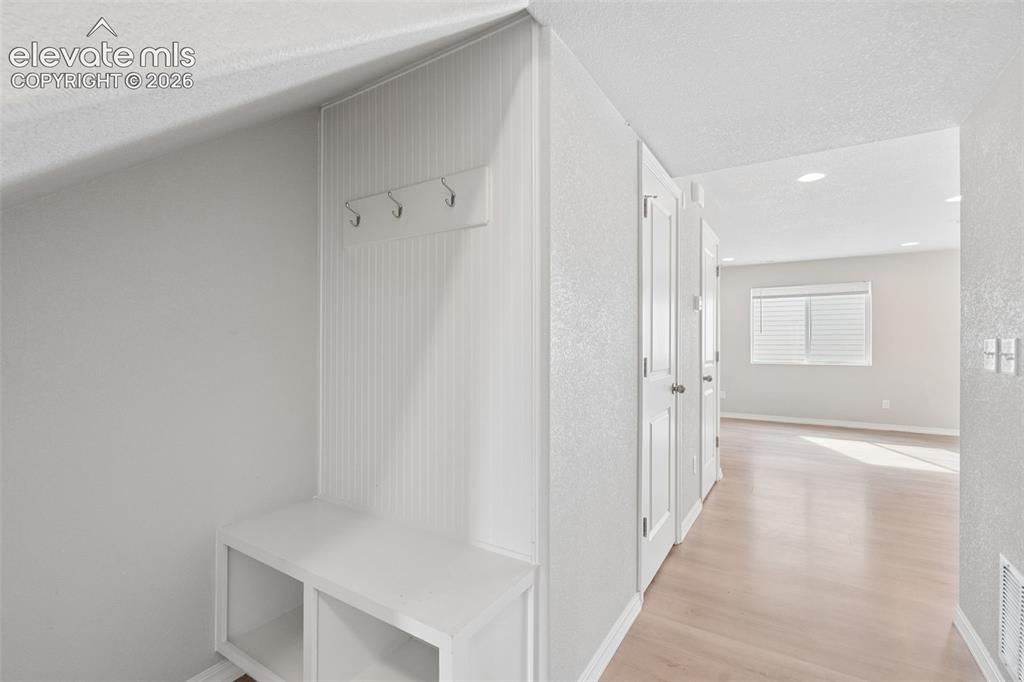 Image 9 of 36: Built-in shelving and hooks are conveniently located by the home