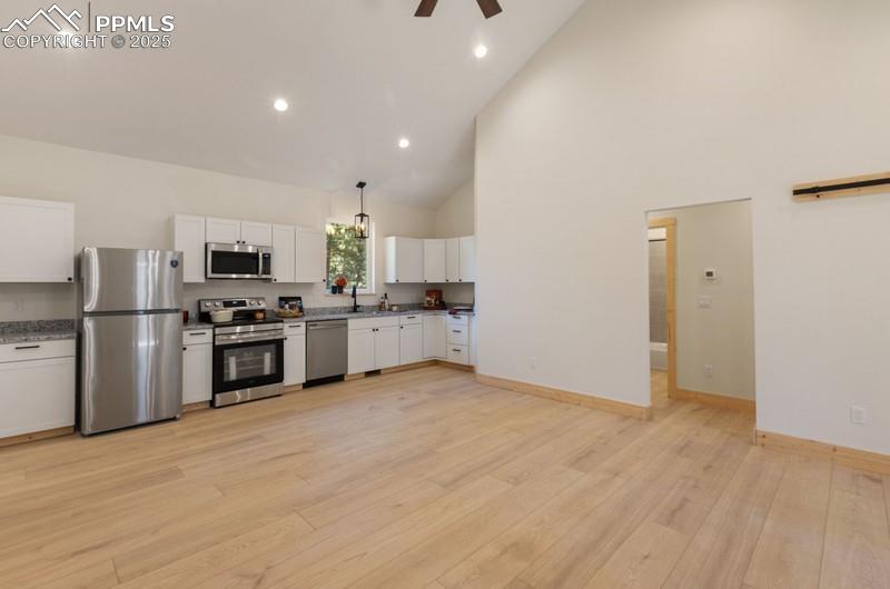 Image 11 of 37: Kitchen with stainless steel appliances, granite countertops, high vaulted 