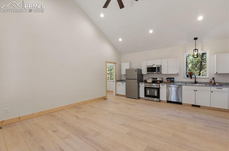 Image 12 of 37: Kitchen featuring white cabinetry, Granite Countertops, high vaulted ceilin