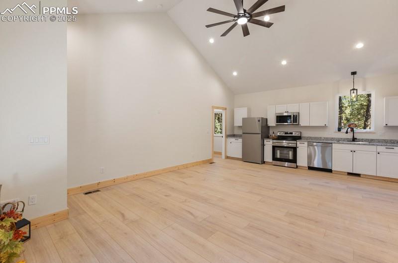 Image 16 of 37: Kitchen featuring high vaulted ceiling, appliances with stainless steel fin