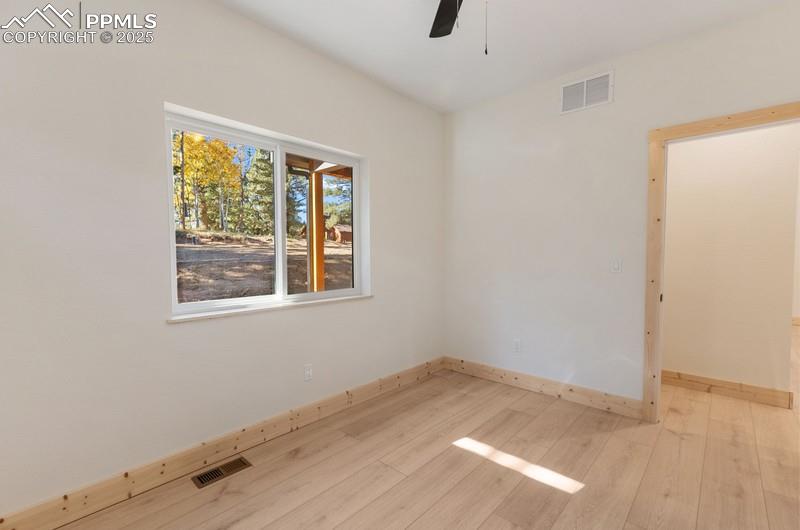 Image 21 of 37: Bedroom #2 at the front of the home featuring light wood-style floors and a