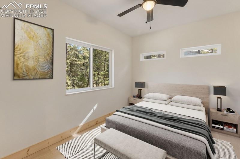Image 25 of 37: Virtually Staged Master bedroom with wood finished floors and ceiling fan